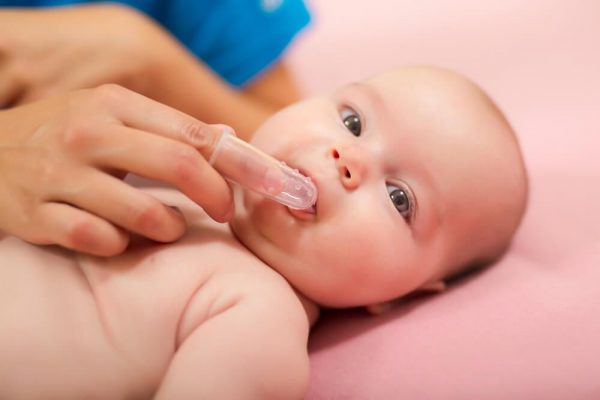 рука чистит зубы малышу напальчником